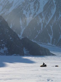 Person using snow mobile to cross a snow covered valley